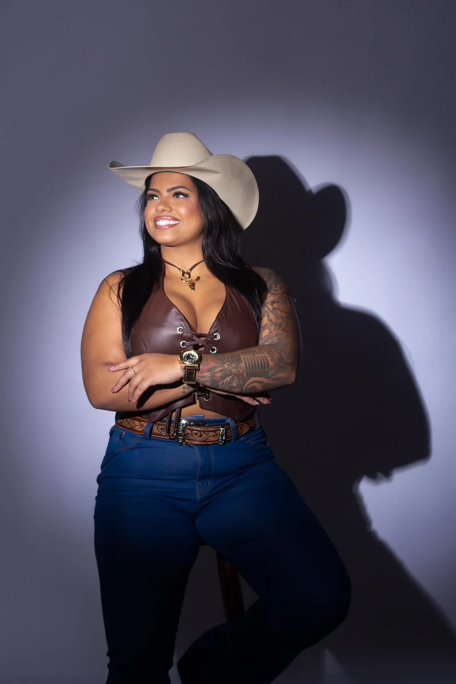 Jéssica Faria em ensaio com chapéu e luz de palco